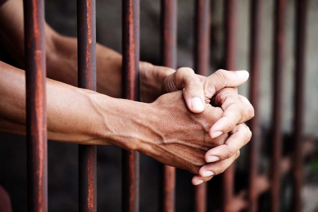 Hands of prisoner in jail.