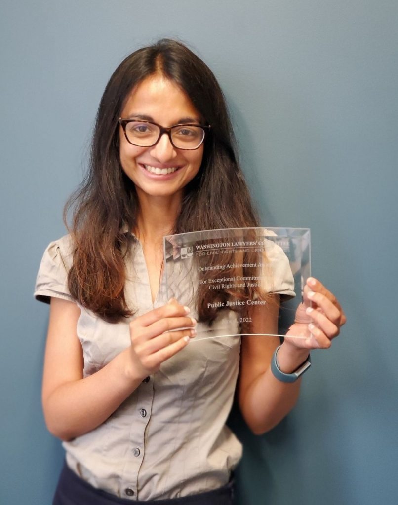 Monisha Cherayil holding award.