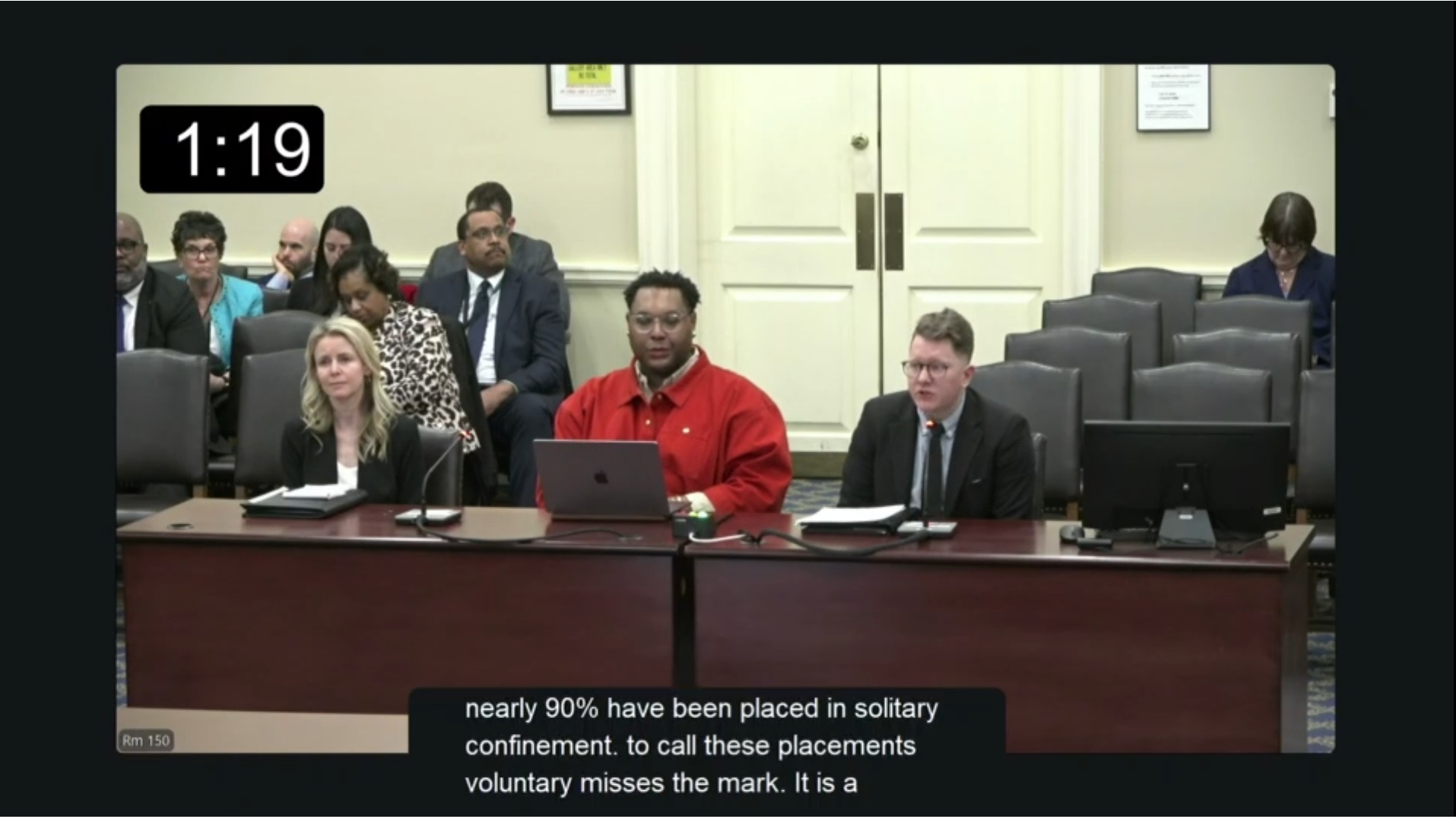 Three people testifying in a legislative hearing